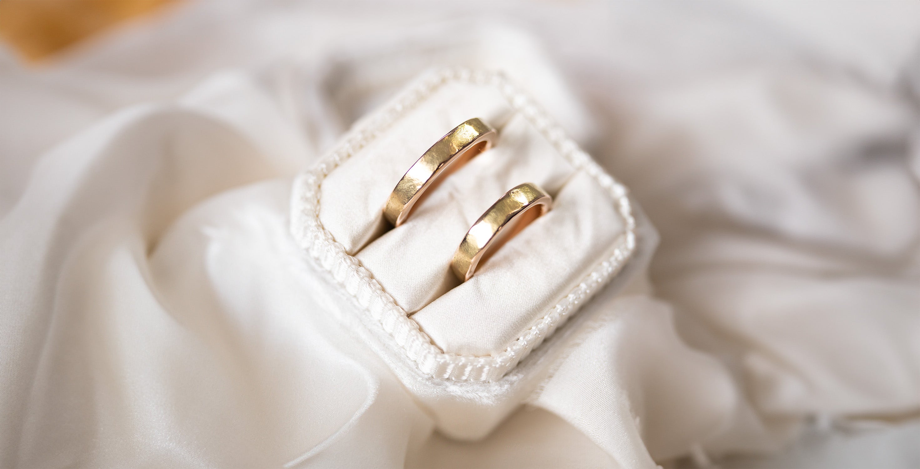 A matching pair of textured golden wedding rings, handmade for a couple at our artisan jewelry studio.